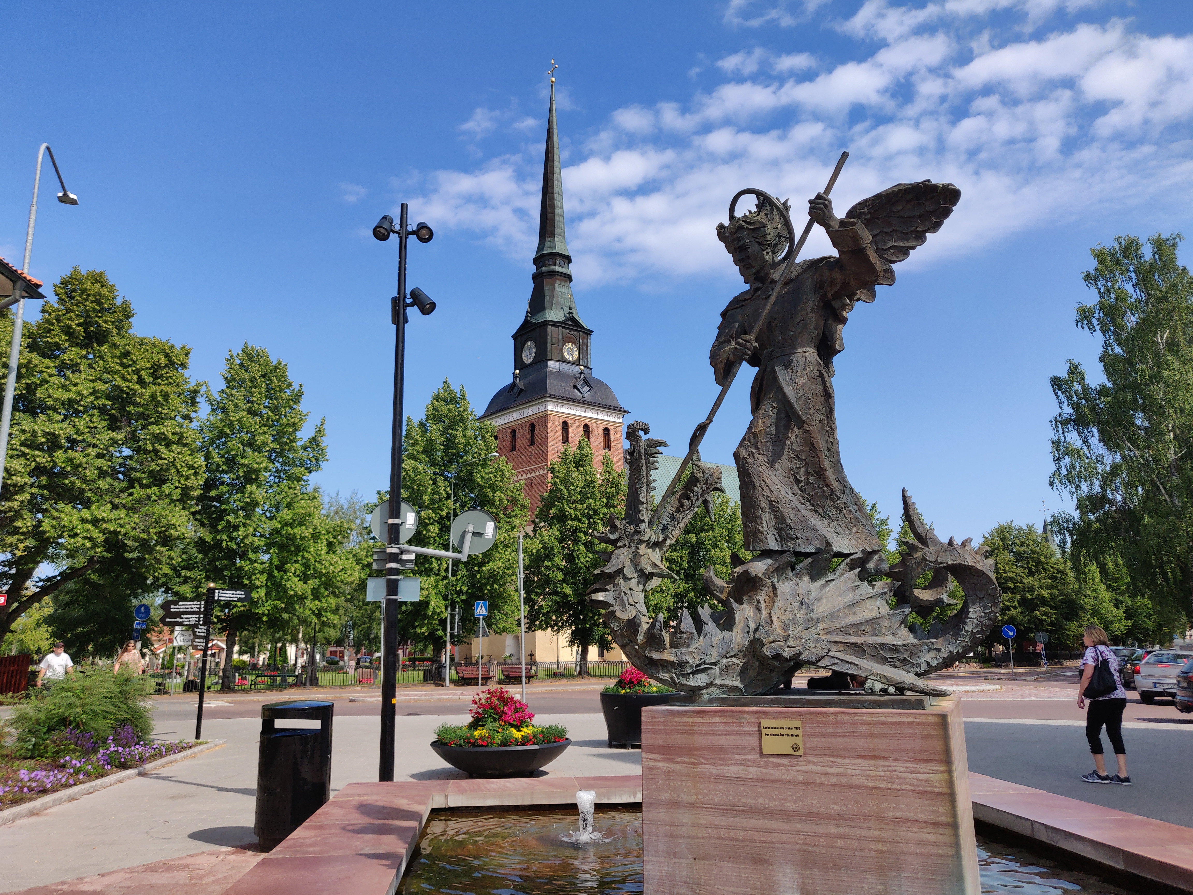 Mora gågata med statyn av St: Mikael och draken i förgrunden och Mora kyrka i bakgrunden.