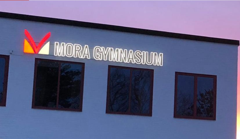 Husvägg på Mora gymnasium med logotyp.