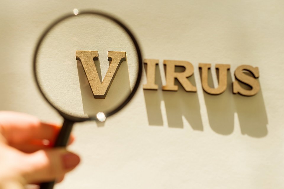 Texten Virus med ett förstoringsglas som förstorar bokstaven v.