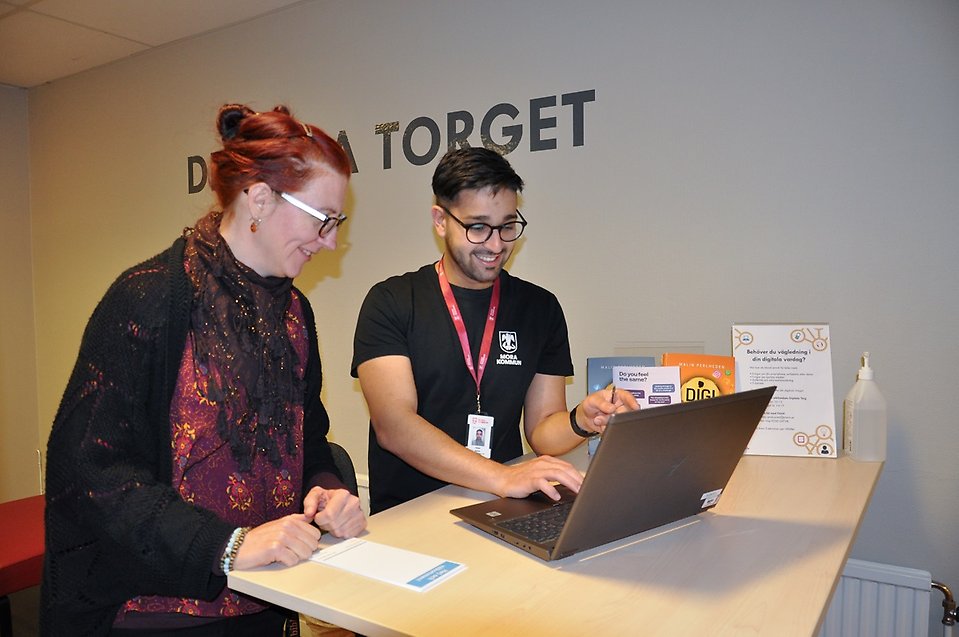 Foto på Sonja Viklund och Omid Azimi som kollar ner mot en dator och ler.