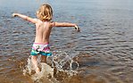 Ett barn som springer i vattnet på en strand