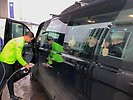 Tränare Kalle Björkman tankar en av Mora gymnasiums bilar med HVO-bränsle. Två elever som sitter i bilen gör tumme upp.
